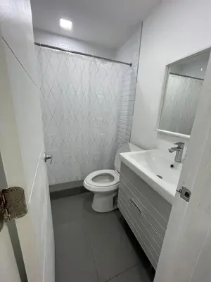 a white bathroom with a toilet and a sink at Stylish Pool Home in Hollywood