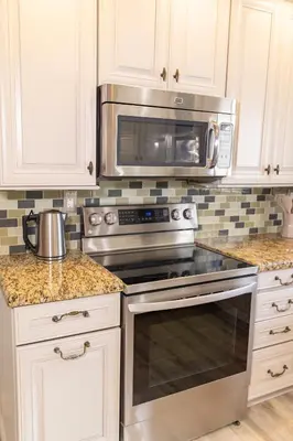 a kitchen with a stove and a microwave at Private Villa with Pool and Sauna in Dania Beach