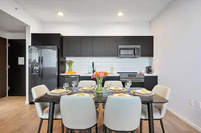 a kitchen with a dining room table with white chairs at Downtown by Miami Vacation Rentals in Miami