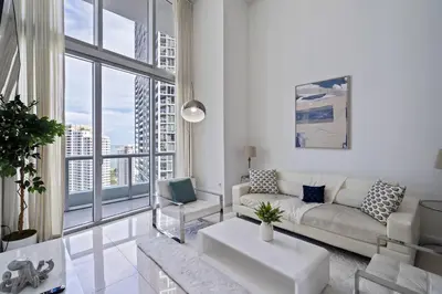 a living room with a couch and a large window at Icon 1 Bed With Water Views 16 ft Ceilings and Free Spa Access in Miami