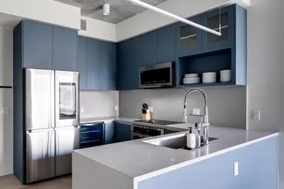 a kitchen with blue cabinets and a white refrigerator at Kasa Wynwood Miami in Miami