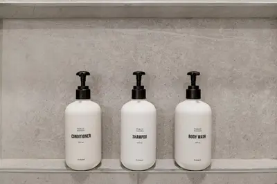 a group of three shampoo bottles sitting on a shelf at Kasa Wynwood Miami in Miami