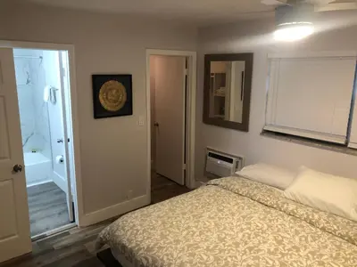 a bedroom with a bed and a bathroom with a shower at City First Story Apartments & Cottage in Fort Lauderdale