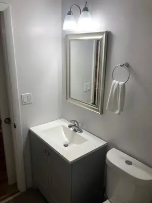 a bathroom with a sink and a mirror and a toilet at City First Story Apartments & Cottage in Fort Lauderdale