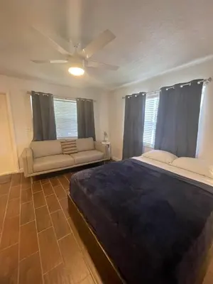 a bedroom with a large bed and a couch at City First Story Apartments & Cottage in Fort Lauderdale