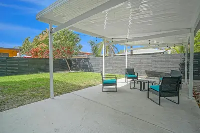 a patio with chairs and a table under a white canopy at Elegant Wynwood Flats in Miami