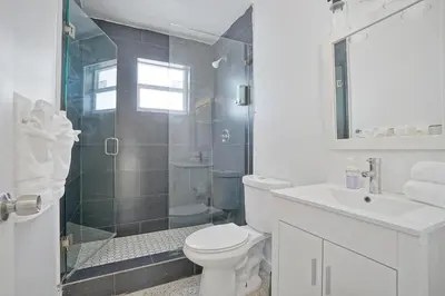 a bathroom with a shower and a toilet and a sink at Elegant Wynwood Flats in Miami