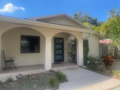 a small white house with a black door at Fort Lauderdale Party house! in Fort Lauderdale