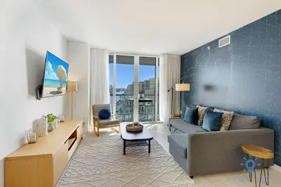 a living room with a couch and a table at Spectacular Infinite View Balcony Pool Gym in Hallandale Beach