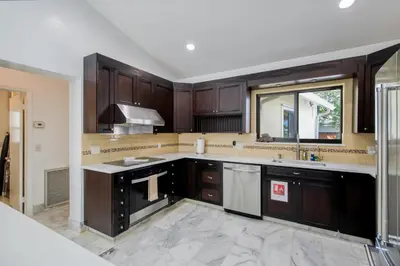 a kitchen with dark wood cabinets and a sink at Marble House in Lauderdale Harbours in Fort Lauderdale