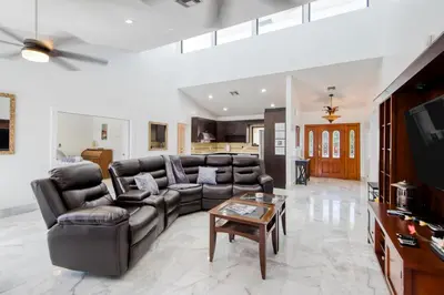 a living room with leather couches and a table at Marble House in Lauderdale Harbours in Fort Lauderdale