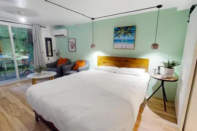 a bedroom with a large bed and a living room at Walking On Sunshine - Studio in Fort Lauderdale