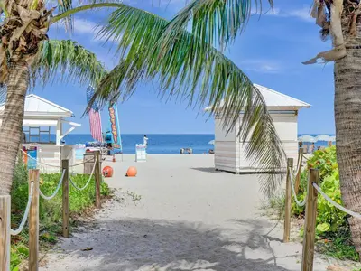 a beach with a palm tree and a volley ball court at Awesome Beach Condo with Resort Amenities 1016 in Miami Beach