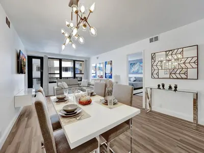 a dining room and living room with a white table and chairs at Awesome Beach Condo with Resort Amenities 1016 in Miami Beach