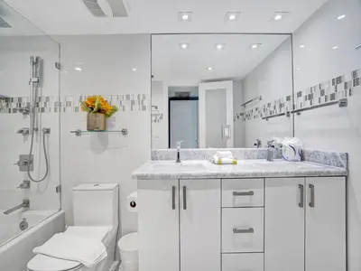 a white bathroom with a toilet and a sink at Beachfront Condo w Beach Service 1207 in Miami Beach
