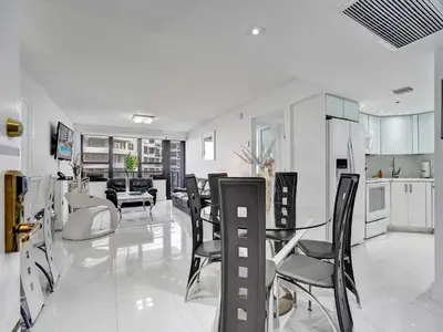 a kitchen and living room with a table and chairs at Beachfront Condo w Beach Service 1207 in Miami Beach