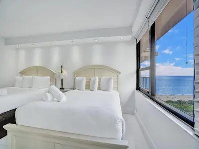 a bedroom with two beds and a large window at Beachfront Condo w Beach Service 1207 in Miami Beach
