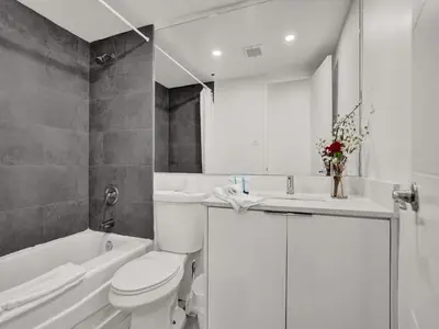 a white bathroom with a toilet and a sink at Gorgeous Miami Beach Condo 1614 in Miami Beach
