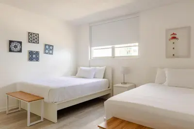 two beds in a room with white walls and a window at Apt w/2 Queen Beds & Ocean View at Tides in Hollywood