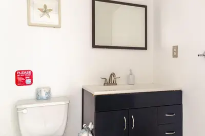 a bathroom with a sink and a toilet and a mirror at Apt w/2 Queen Beds & Ocean View at Tides in Hollywood