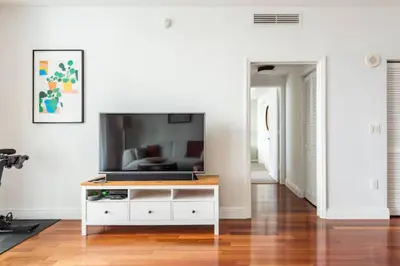 a living room with a television on a white cabinet at Brickell High Rise Living at its best! w/ Pool Gym in Miami