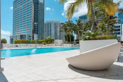a large pool with palm trees and buildings at Brickell High Rise Living at its best! w/ Pool Gym in Miami