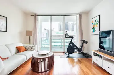 a living room with a white couch and a treadmill at Brickell High Rise Living at its best! w/ Pool Gym in Miami
