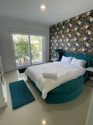a bedroom with a large bed with a blue headboard at NEW 3 Story in Homestead- 3/2.5 Balcony & Rooftop in Homestead