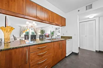 a large kitchen with wooden cabinets and white appliances at Luxury 1 BDR • 30th Floor • Brickell • Water Views in Miami