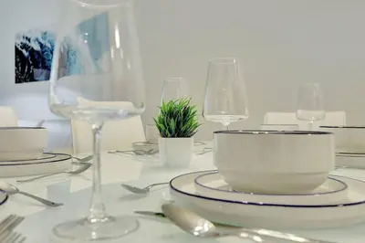 a white table with glasses and plates and a bowl at Lux 1B condo with XL Balcony, Pool, Gym & Games in Miami