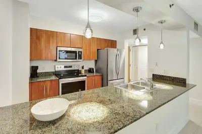 a kitchen with a counter top and a refrigerator at Lux 1B condo with XL Balcony, Pool, Gym & Games in Miami