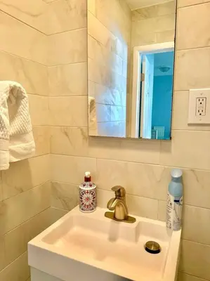 a bathroom sink with a mirror and a bottle of soap at Lugar encantador balcón vista al agua in North Miami Beach