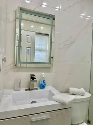 a white bathroom with a sink and a mirror at Lugar encantador balcón vista al agua in North Miami Beach