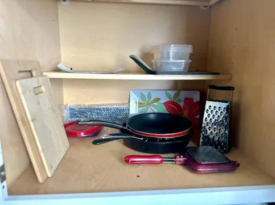 a shelf with a pan and other items in a drawer at Lugar encantador balcón vista al agua in North Miami Beach