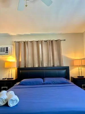a bedroom with a blue bed with two towels on it at Lugar encantador balcón vista al agua in North Miami Beach