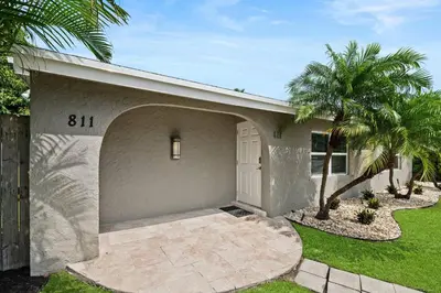 a house with a garage and a palm tree at Casa Mojito in Fort Lauderdale
