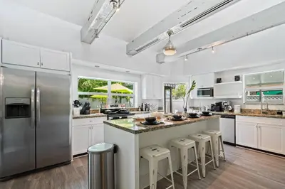 a kitchen with white cabinets and stainless steel appliances at Casa Mojito in Fort Lauderdale