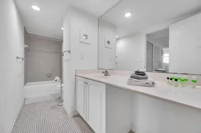 a white bathroom with a sink and a mirror at Spacious 1 BDR 1.5 BTH • Hallandale Beach in Hollywood