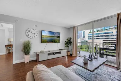 a living room with a couch and a clock on the wall at Beautiful 1 BED 1 BTH • Brickell in Miami