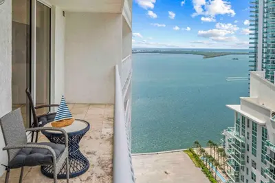 a balcony with a table and chairs and the ocean at Exquisite 1 Bed • 33 Floor •Brickell • Ocean Views in Miami