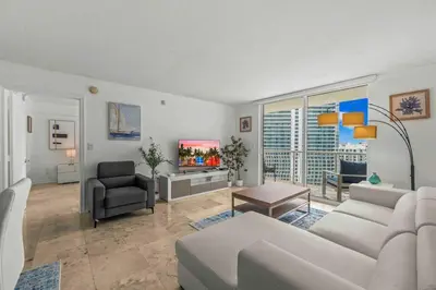 a living room with a white couch and a tv at Exquisite 1 Bed • 33 Floor •Brickell • Ocean Views in Miami
