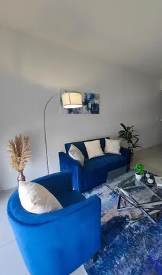 a living room with a blue couch and a table at Stylish 1-Bedroom Getaway Apt- pool & gym in Miami