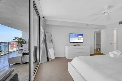 a bedroom with a bed and a balcony with a television at PH 41st Floor 3 BED • Brickell • Ocean View in Miami