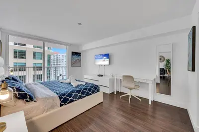 a bedroom with a bed and a desk and a window at Dazzling 1 BED 1 BTH • Brickell • Bay & City View in Miami