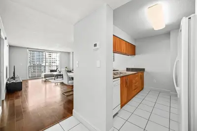 a kitchen with white walls and wooden cabinets at Splendid 1 Bed Apartment • Brickell • Water Views in Miami