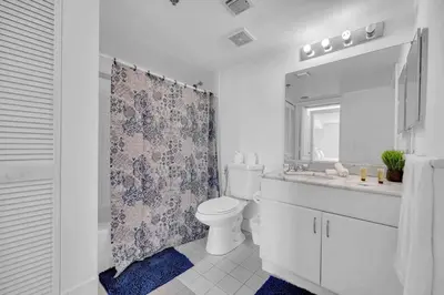 a bathroom with a toilet and a sink and a mirror at LUX 1 BDR 1 BTH • Brickell • Pool & Ocean Views in Miami