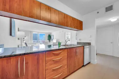 a large kitchen with wooden cabinets and a sink at Luxe 1 BDR •Brickell• Ocean View in Miami