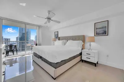 a white bedroom with a bed and a balcony at Luxe 1 BDR •Brickell• Ocean View in Miami