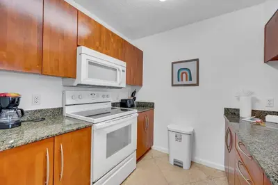 a kitchen with white appliances and wooden cabinets at Ocean view 1BR Condo Brickell-FreeParking in Miami