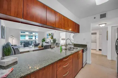 a kitchen with a counter top and a living room at Spacious 36th FLR 1 BD 1 BT • Brickell • Bay View in Miami